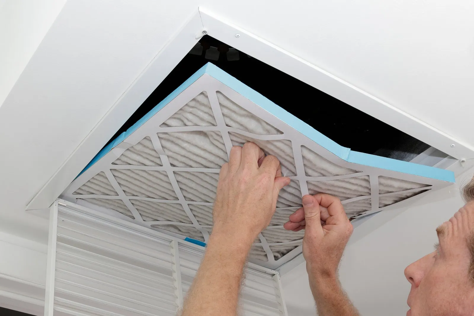 Technician cleaning an air duct vent in a Kissimmee home